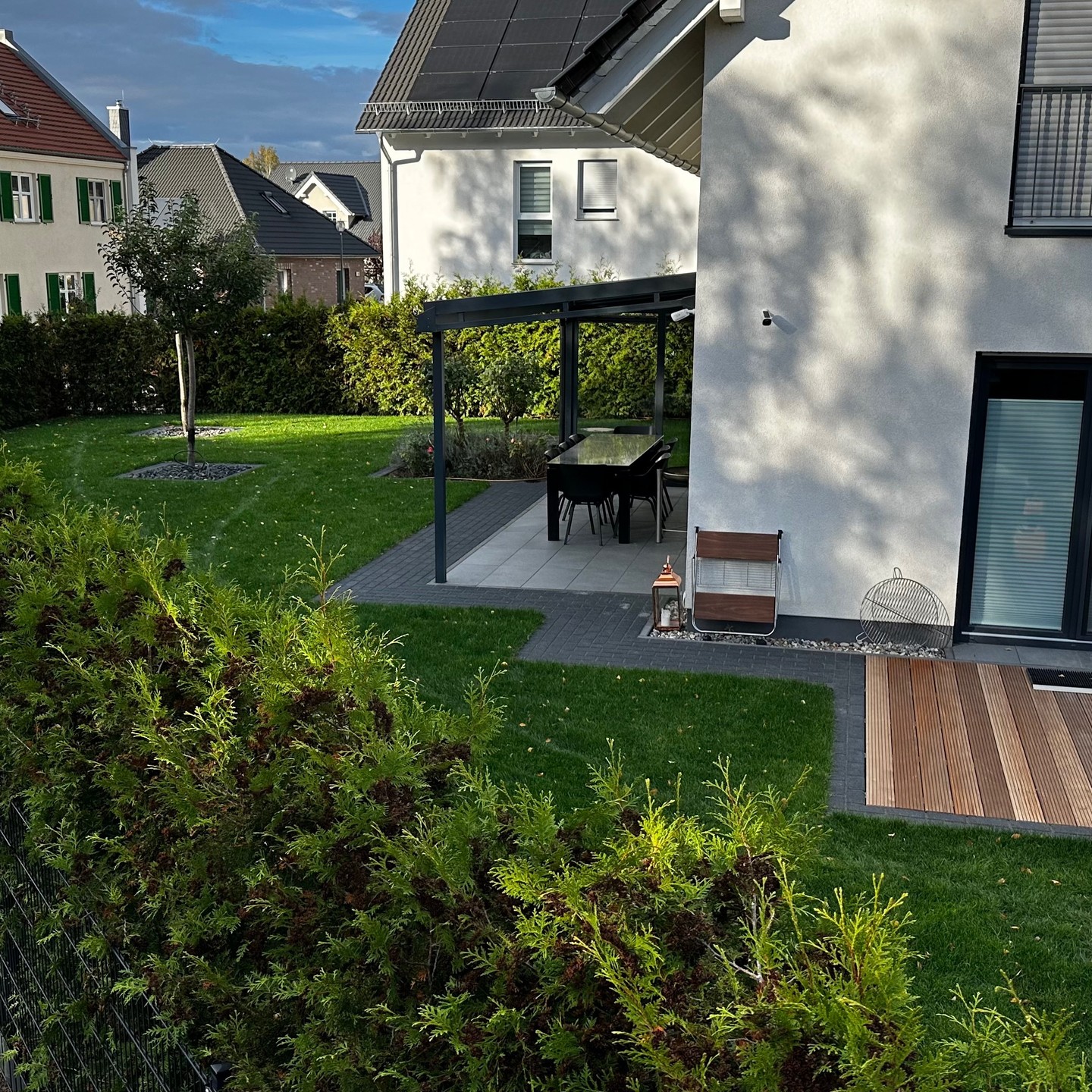 Aussenanlage mit Holzterrasse, Pflasterarbeiten, Rollrasen und RainBird Beregnung hergestellt.